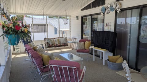 Large cozy screened in front porch with dining area. 