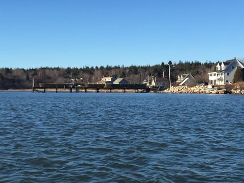 The house is the cape on the far right of the photo.  Gray cape with porch!  