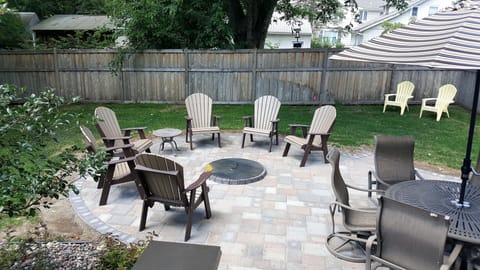 New Paver Patio with Firepit, Dining Table, Couch and  Weber charcoal grill. 