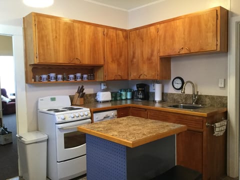 Kitchen with new dishwasher, range, countertops and sink.