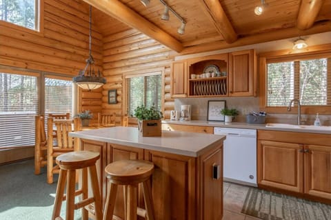 The kitchen features wooden cabinets, modern appliances, and a cozy dining space with bar stools.