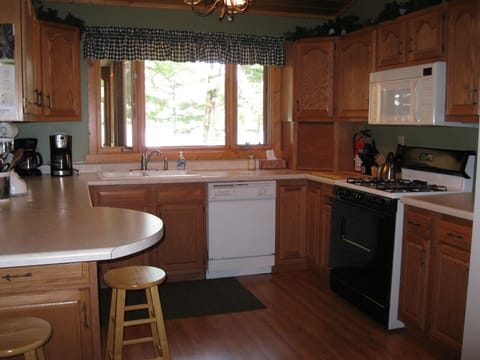 Main level fully stocked kitchen overlooks deck and lake