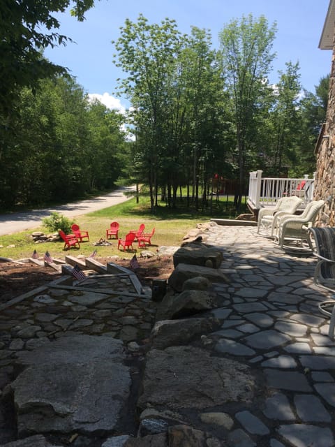 Front rock patio with gas fire pit. Walkway goes down to a gradual sloping beach