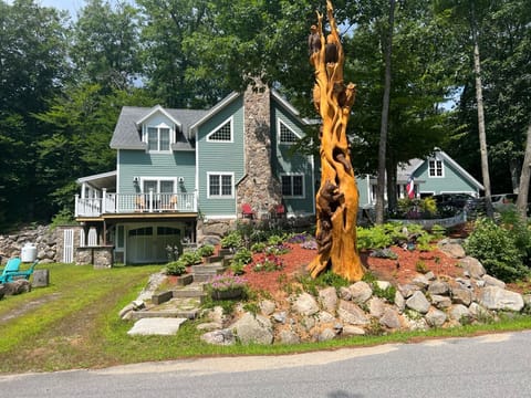 Front of house looking towards lake with 1 wood fire pit & 2 propane fire pits