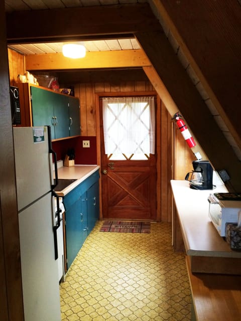 Simple kitchen with range top, oven, microwave and fridge. 