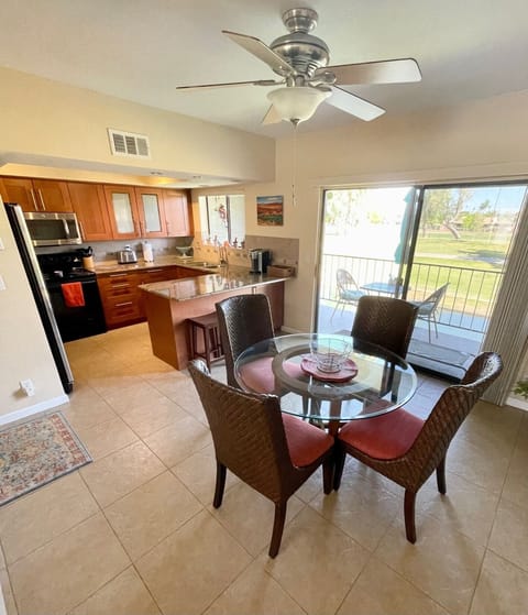 View of dining area and kitchen. Extra chairs at eating bar.