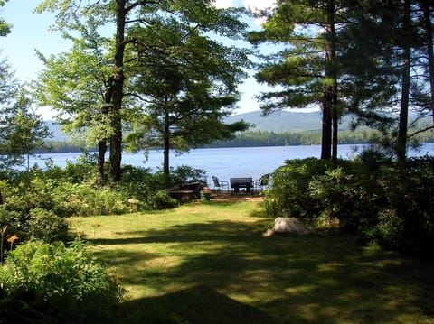 Level garden and terrace overlooking lake and Squam mountain range.