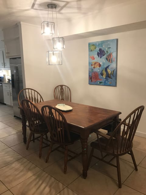 Dining room, with bench behind table. Fun lights and painting. 