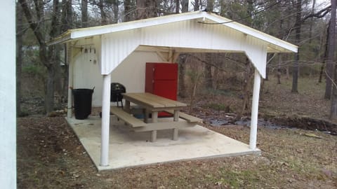 Picnic pavilion includes: picnic table, full size fridge, and charcoal grill.
