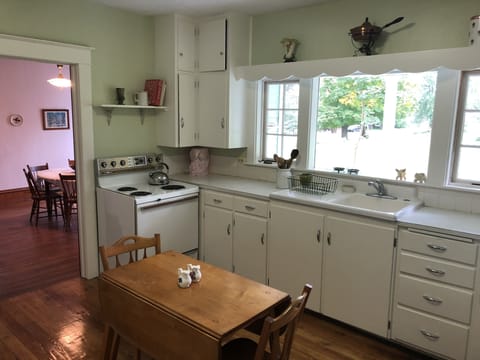 Kitchen with refrigerator, oven, microwave, toaster and small table.