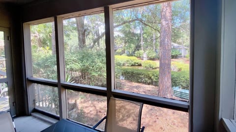 View of the lagoon from screened in porch with table, chairs and ceiling fan