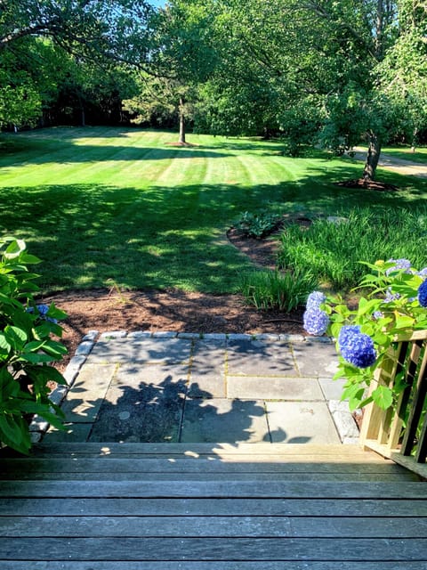 Large, private front yard view from front porch with two adirondack chairs