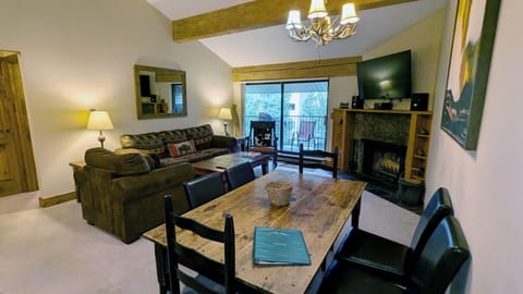 Living room with sofa bed, wood fireplace, and balcony w/ propane BBQ grill