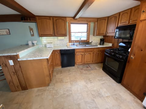 One of two kitchens. Featuring gas stove, microwave, & dishwasher 