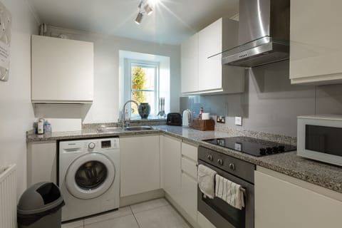 Fully equipped kitchen with washing machine.