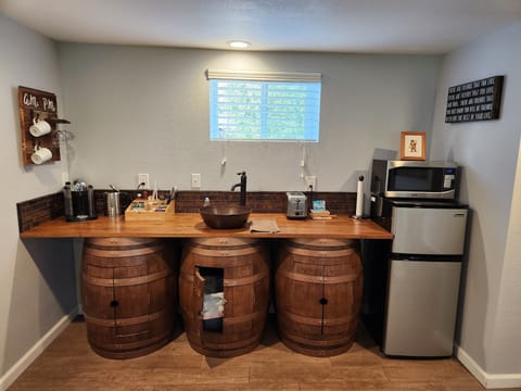 Kitchenette wet bar with fridge, microwave, hot water kettle, and Nespresso.