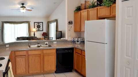 The kitchen overlooks the breakfast bar and lounge/living room beyond.