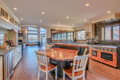 Kitchen with center island with wood counter-top and chairs,oven with range, and plenty of windows.