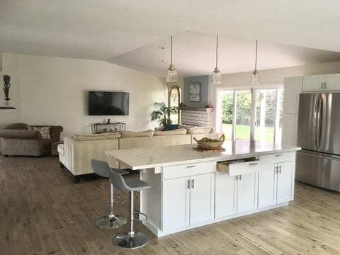 Open floor plan from kitchen to living room, 65 inch Smart TV