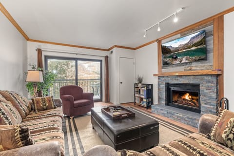 Living room with stacked slate fireplace and smart TV