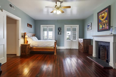 Bedroom 1 features a comfortable wooden bed, ceiling fan, and hardwood floors