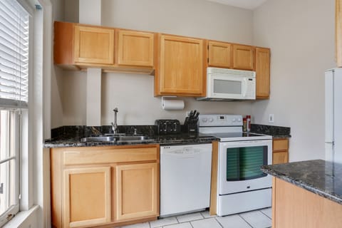 The full kitchen features modern appliances that's perfect for preparing meals.