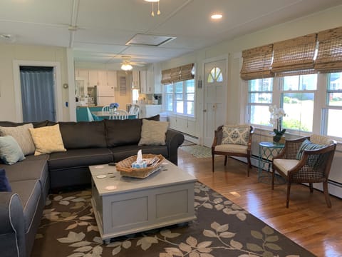 Spacious living room with new sectional sofa, flat screen tv open to kitchen. 