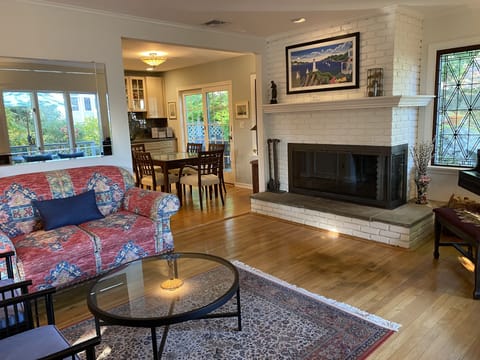 Partial view of living room, fireplace, dining area.