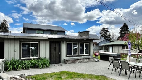 Front of the house with dining table, hot tub, and side yard