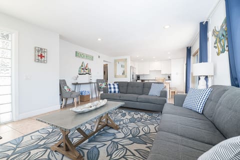 The living room invites easy conversation, afternoon lounging, and cozy evenings with the ocean only steps away