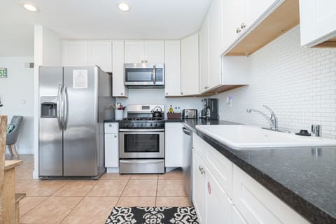 Crisp white cabinetry, sleek countertops, and stainless steel appliances come together in this coastal kitchen