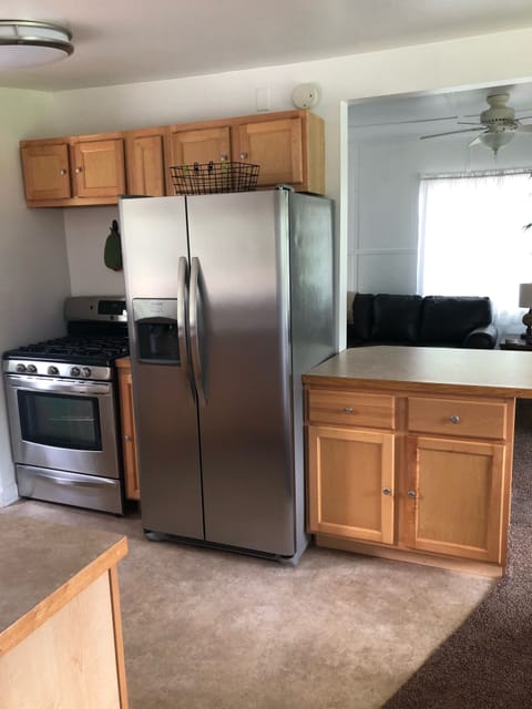 Stainless Refrigerator w/ water and ice dispenser in door.  Gas stove