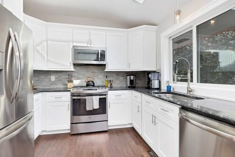 Main level kitchen with all the supplies you'll need such as sugar and spices as well as enough dishes, silverware, pots, and pans for any size gathering!