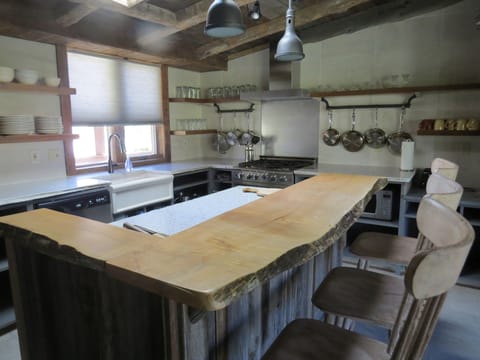 The kitchen with granite countertops and natural wood bar with seating.