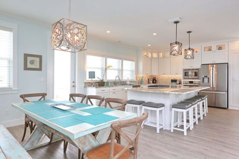 Open kitchen with separate dining table and large island with seating for seven