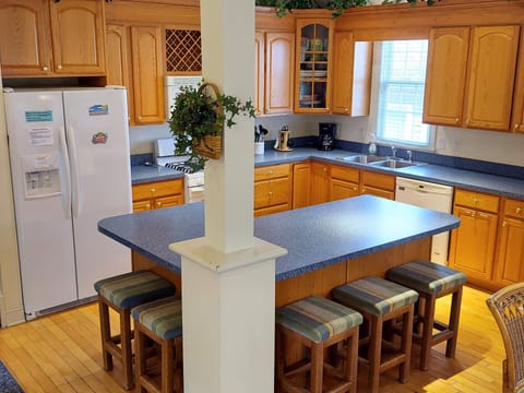 Spacious and well-stocked kitchen with 5 bar stools