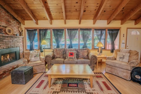 Enjoy a spacious open-concept design where the kitchen, dining, and living room flow together seamlessly, highlighted by large windows, a gas fireplace, and a flat-screen TV.