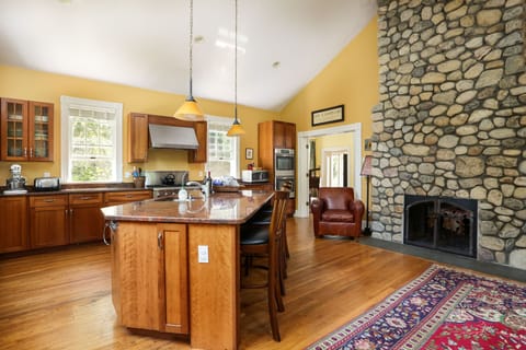 The fully equipped kitchen features a dramatic native stone fireplace
