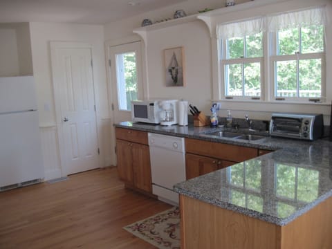 A small sunny deck with table, chairs and grill adjoin the kitchen.