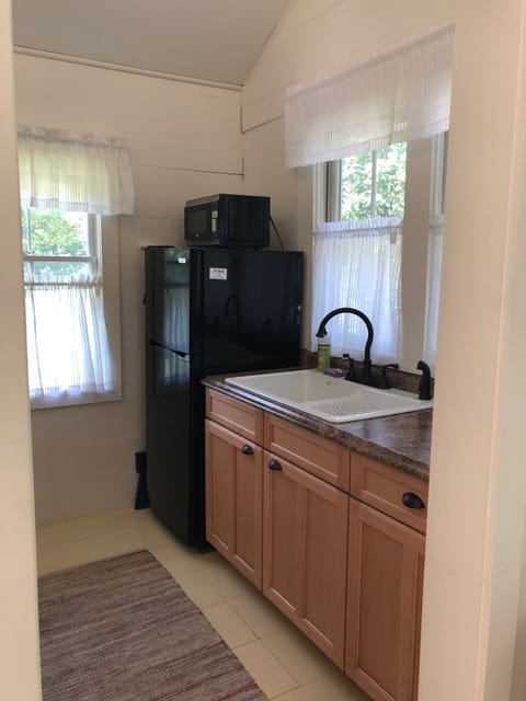 Refrigerator with microwave on top of it