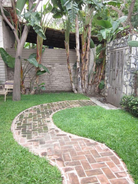 View out the back door, off bedroom. Adobe and stone walled garden.