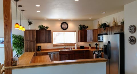 Large kitchen with bamboo countertops, dishwasher, ice maker, and gas range.