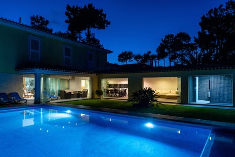 Pool, outside living and dining area at night