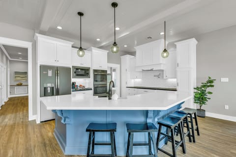 Fully equipped kitchen: double ovens, two fridges, stainless-steel appliances.