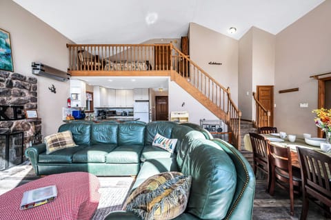 Living room couch and wood burning fireplace. Steps lead to Master bedroom