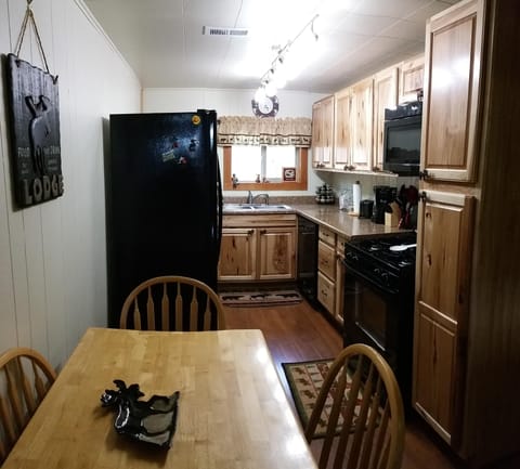 Dining area and kitchen with full size refrigerator, dishwasher, gas stove/oven.