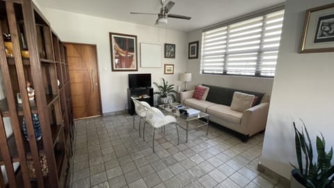 Living room with a 28 smart tv, wifi, air conditioning and a ceiling fan.
