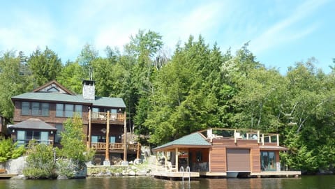 View from lake of house and boathouse with boat storage, side deck, game room