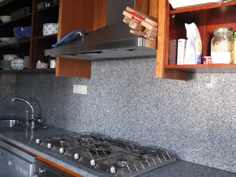 Kitchen with five burner gas stove, electric oven, dishwasher, granite counters