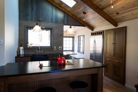 Metal on the wall is by Doyle Svenby. Kitchen design by Tim Bye.